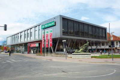 Na lokaciji dotrajanega zadružnega doma v Zalogu v Ljubljani je zrasla večja trgovina Spar, pred katero je urejen manjši trg, v nadstropju pa so knjižnica, večnamenska dvorana, športna dvorana in drugi prostori lokalne skupnosti. Arhitektura: Bernhard Bügelmayer in Jurij Kolenc.