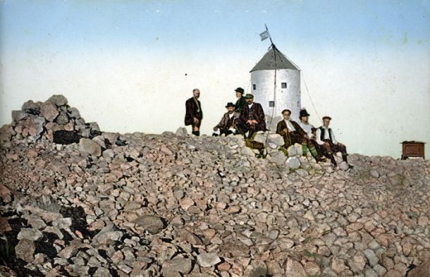 Kolorirana razglednica vrha Triglava iz leta 1912, na njej je dobro vidna zastavica z letnico 