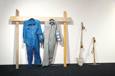 Instalacija Oblačilo XI prikazuje osebno izkušnjo, ko je umetnik Tomaž Furlan za preživetje opravljal garaško delo na gradbišču, a zanj ni prejel plačila.