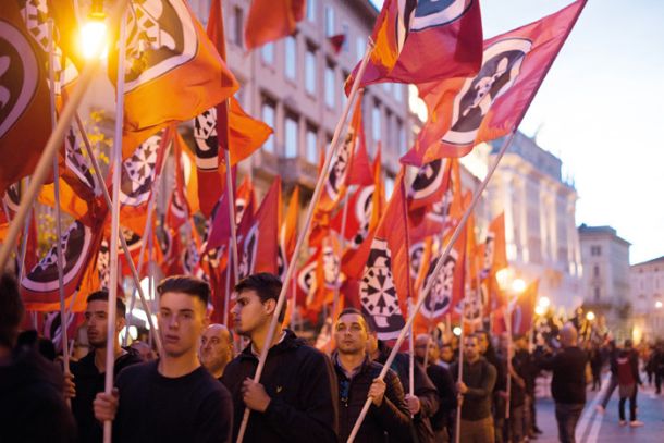 Člani gibanja CasaPound na pohodu po ulicah Trsta s svojimi zastavami v rokah, rdečimi s podobo želve v obliki tarče. Shoda se je udeležilo njegovih 2000 članov.