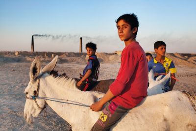 Dečki se vračajo s težaškega dela v opekarni. Nadžaf, Irak. 