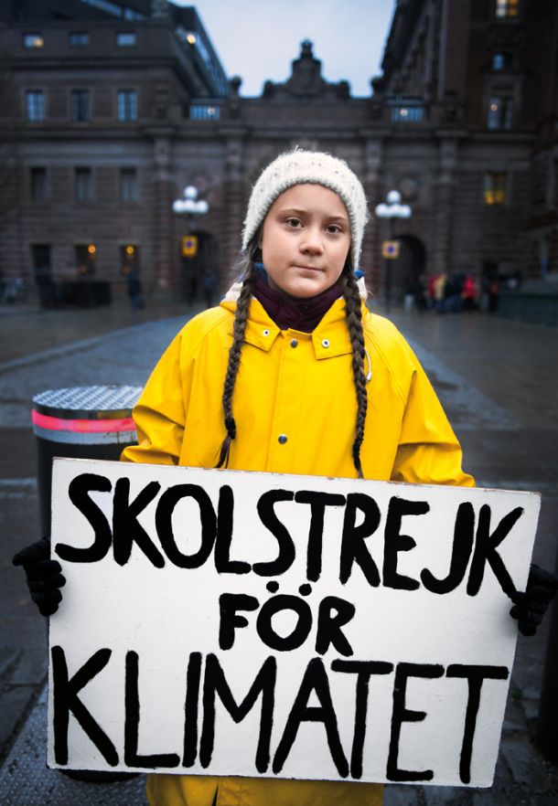 Greta Thunberg pred stavbo švedskega parlamenta v petek, 30. novembra 2018. V rokah nosi napis, na katerem piše »šolska stavka za podnebje«.