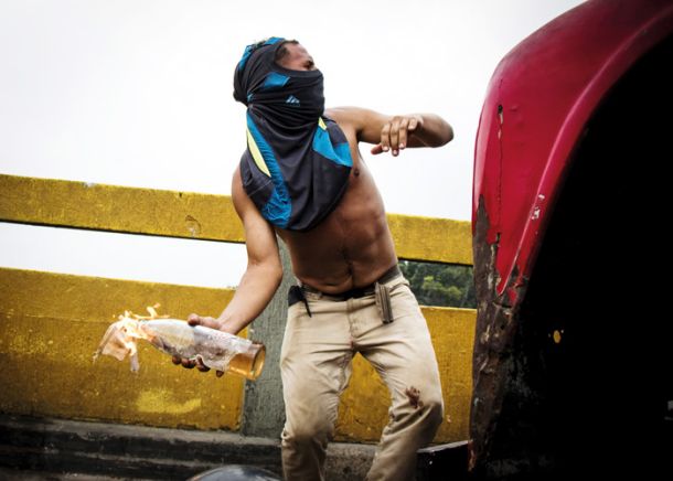 Nasprotnik Madura pri metanju molotovke na mostu, kjer je zagorel humanitarni konvoj