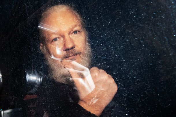 Julian Assange ob policijskem prevozu na sodišče, aprli 2019