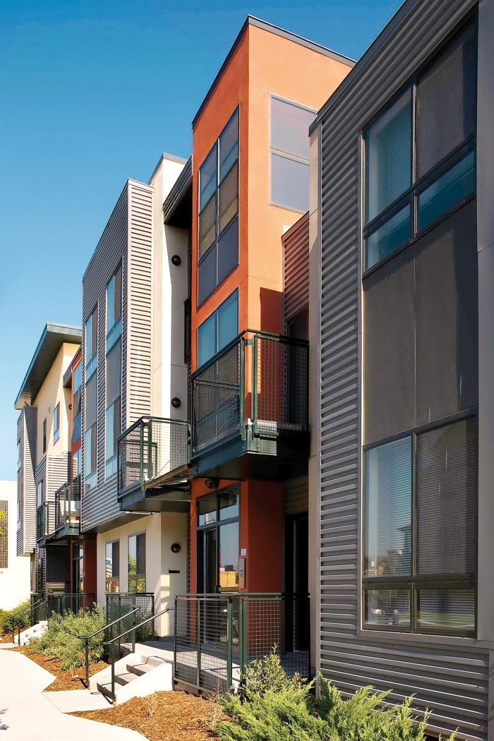 Na obrobju Denverja je na obširnih parkirnih površinah propadlega nakupovalnega središča zraslo mešano stanovanjsko-poslovno območje Belmar s tradicionalnimi ulicami, od takih z živahnim javnim programom v pritličju do mirnejših stanovanjskih, kakršna je prikazana na sliki (Belmar Apartments, arhitektura Van Meter Williams Pollack). /