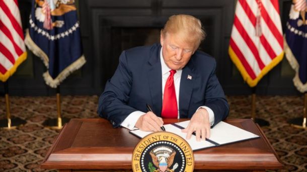 Donald Trump lani med podpisovanjem umika sankcij proti Iranu 