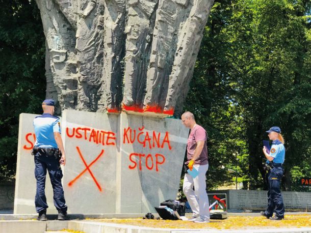Napis USTAVITE KUČANA na spomeniku revolucije v Ljubljani