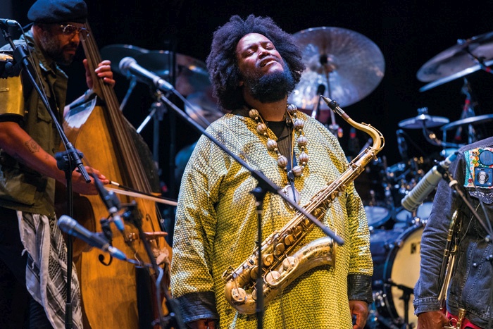 Kamasi Washington navdušuje z nasprotji, ki so vpeta v aranžmaje dinamik in prepletanj, dodaten kontrast pa gradi med performativnim angažmajem in zenovsko odrsko držo.
