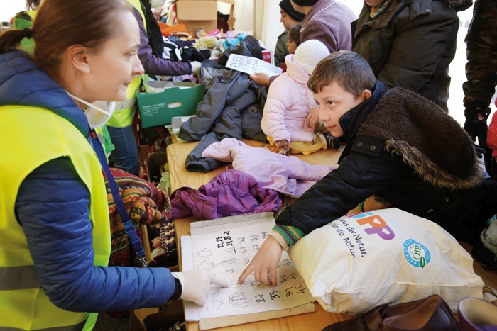 Sporazumevanje beguncev in humanitarnih delavcev, ko je jezikovna bariera prevelika. Prizor iz časov begunske krize konec leta 2015, ko je Slovenijo prečkalo večje število ljudi.