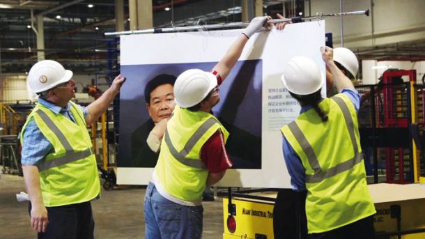 Neusmiljeni magnat, direktor in lastnik korporacije Fuyao Glass, alias »chairman Cao«, skoraj »chairman Mao«, »kralj stekla« na plakatu motivacije v tovarni 