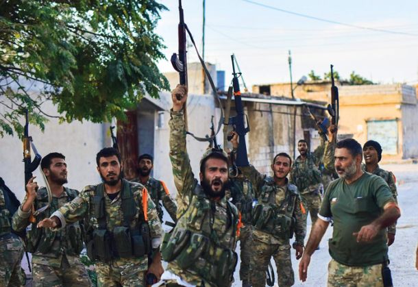 Turčija v vojaških operacijah proti Kurdom v Siriji že dlje časa uporablja tudi enote arabskih islamistov, organizirane v tako imenovano Sirsko narodno vojsko. Njeni pripadniki (na fotografiji) so že zakrivili številne zločine zoper civilno prebivalstvo.