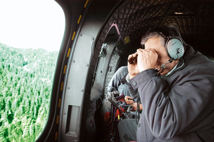 Pokojni ljubljanski nadškof Alojz Uran med opazovanjem katoliških gozdov iz helikopterja