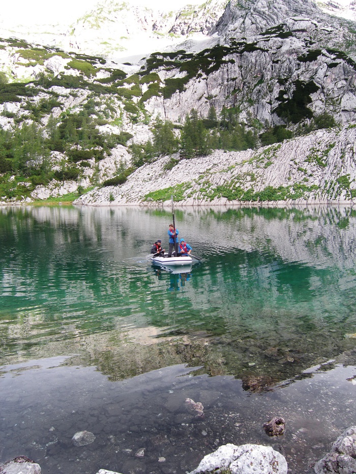 Geologi s pomočjo čolna odvzemajo vzorce iz jezera v Ledvicah v dolini Triglavskih jezer. S pomočjo usedlin lahko analizirajo dogajanje za do 15 tisoč let nazaj.