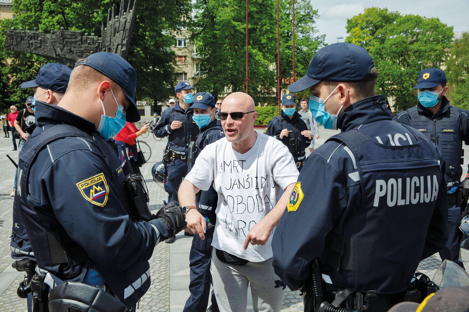 Policijsko popisovanje enega izmed protestnikov med demonstracijami, na katerih je sodeloval kasneje pridržani Ladislav Troha,  1. maja  2020, opoldne.
