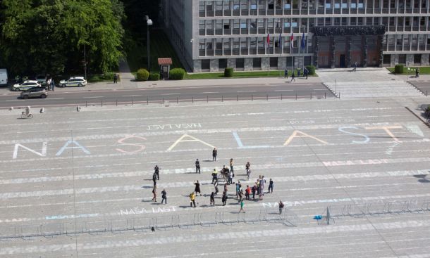 Predprotestno jutranje dogajanje na Trgu republike pred parlamentom ... ljudje so vzeli v roke krede in na ograjeno prizorišče napisali NAŠA LAST.