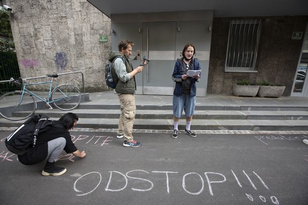 Jaša Jenull in drugi protestniki med pisanjem s kredo po asfaltu