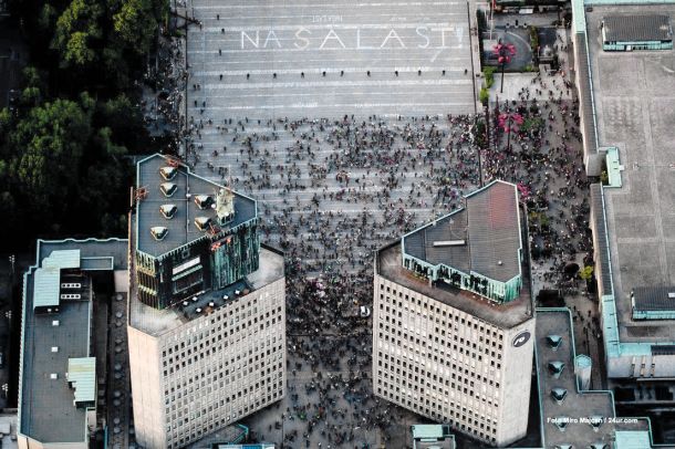 Zračni posnetek kolesarskega protivladnega protesta v Ljubljani. Protestniki so zjutraj na ograjeni del trga s kredo zapisali: Naša last.