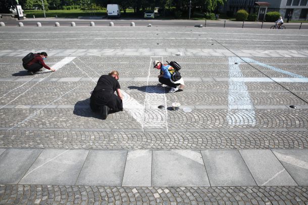 Izdelava napisa »Naša last« na Trgu Republike pred kolesarskim protestom (fotografija iz ptičje perspektive je na strani 49)