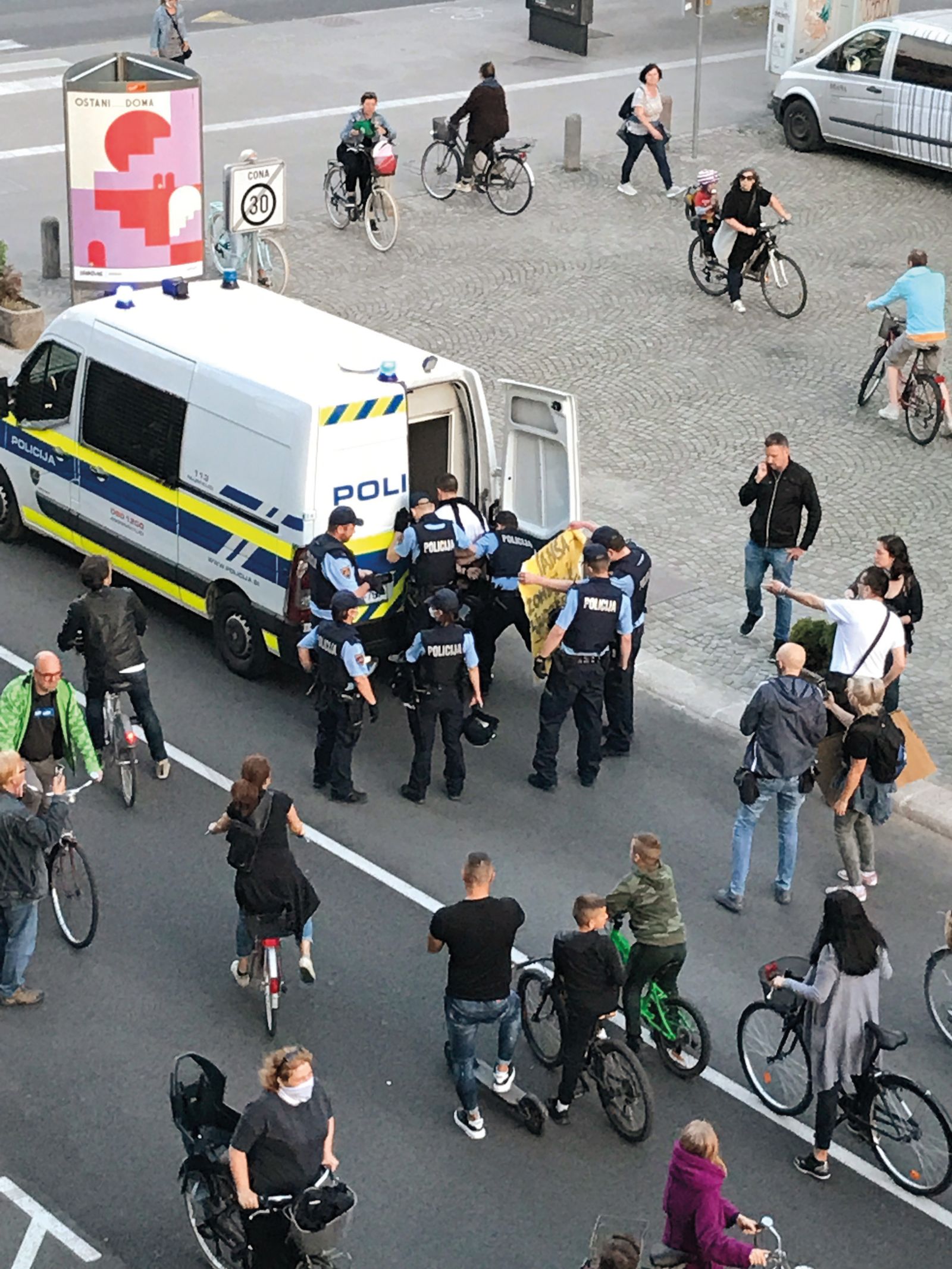 Pridržanje protestnika, ki je imel na transparentu med drugim zapisani tudi besedi Janša in zombi. Ker naj bi odklonil identifikacijo, so ga policisti strpali v marico.