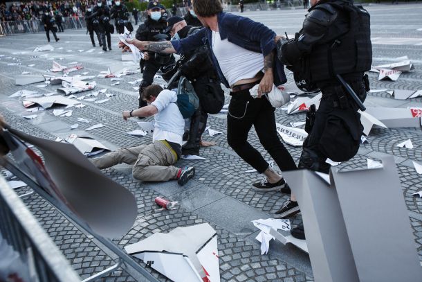 Incident na petkovih protestih, v katerem je policija nasilno odpeljala pet protestnikov, ki so preskočili ograjo, da bi pobrali papirnate aviončke