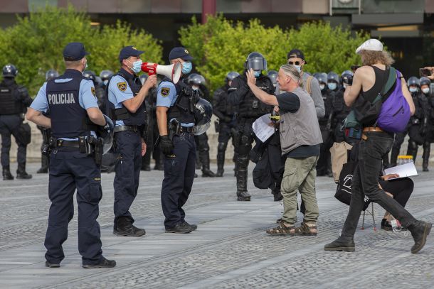 Utrinek s petkovega miroljubnega protesta na Trgu republike, na katerem so protestnice in protestniki brali slovensko ustavo, policija pa jih je nato fizično odstranila