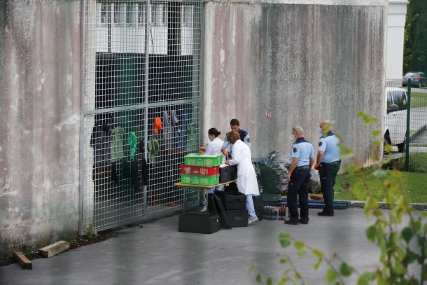 Čas kosila za zaprte tujce v Centru za tujce v Postojni. Hrano dobijo skozi nekaj centimetrsko režo v mreži, s katero so 24 ur na dan zaprti v opuščenem industrijskem objektu.