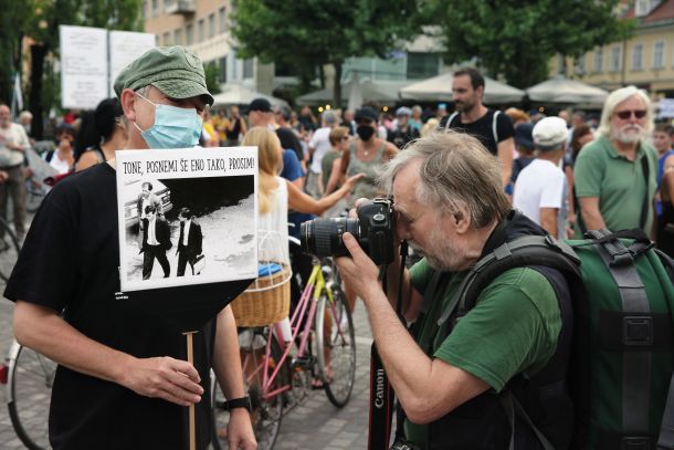 Tone Stojko na petkovem protestu fotografira fotografijo, ki jo je posnel 31. maja 1988 ob aretaciji mladega Janeza Janše