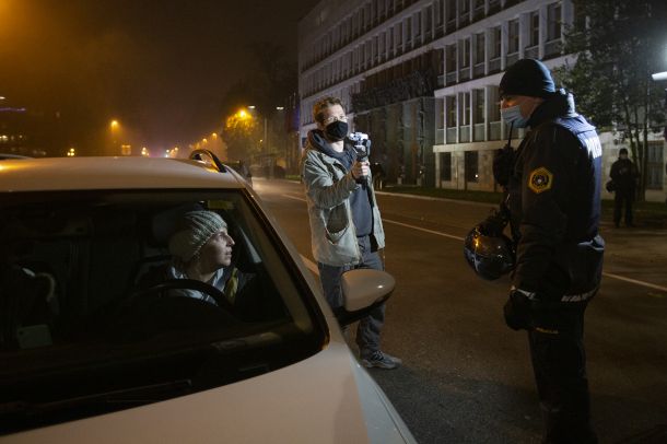 Jaša Jenull na petkovem avtomobilskem protestu snema policista, ki piše kazen protestniku v avtomobilu