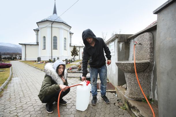 Jasna Hudorovič in Kemi Brajdič na pokopališču med polnjenjem plastenke z vodo 