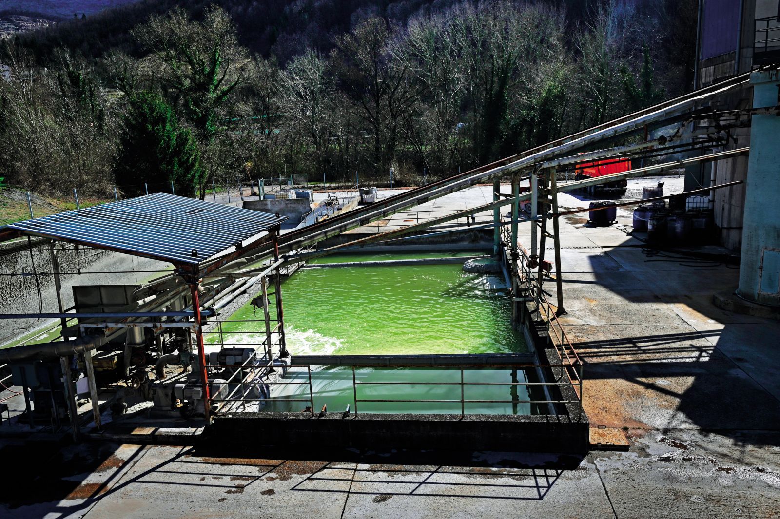 Industrijska čistilna naprava, pod katero potekajo vodovodne cevi s pitno vodo.