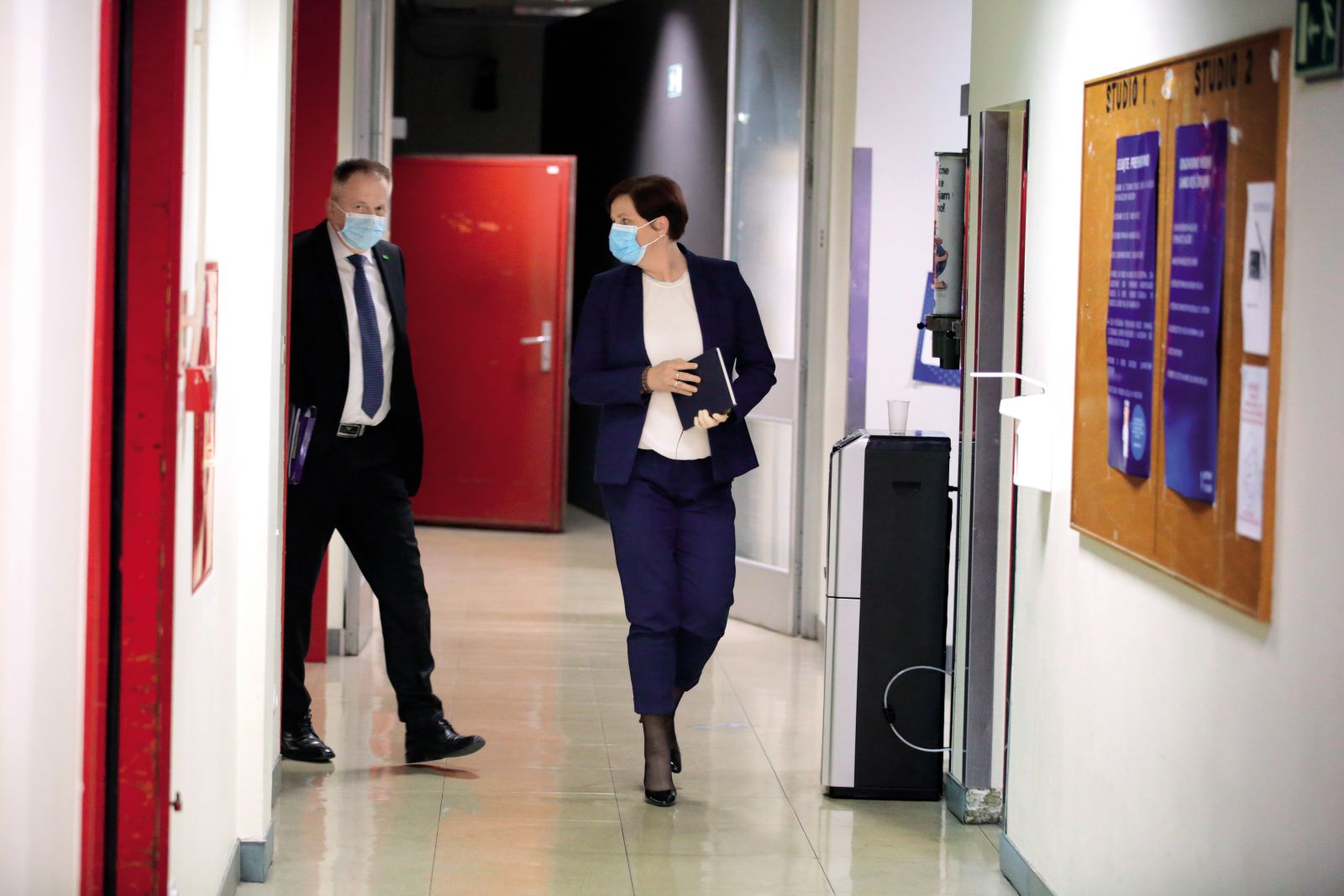 Jelka Godec je pri nabavi zaščitne opreme ločena institucija. Samostojno je, prek svojega strankarskega e-naslova, komunicirala s ponudniki, dajala usmeritve in podobno. Kasneje je na družbenih omrežjih trdila, da ima čisto vest. Na sliki z ministrom Zdravkom Počivalškom pred oddajo Tarča na RTV Slovenija.