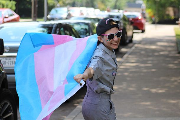 Transspolni fant z zastavo v barvah, ki simbolizirajo transspolnost