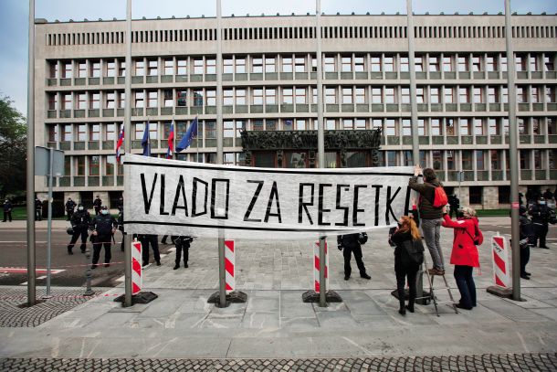 Izvirna uporaba še sveže postavljenih drogov za zastave pred stavbo slovenskega parlamenta 