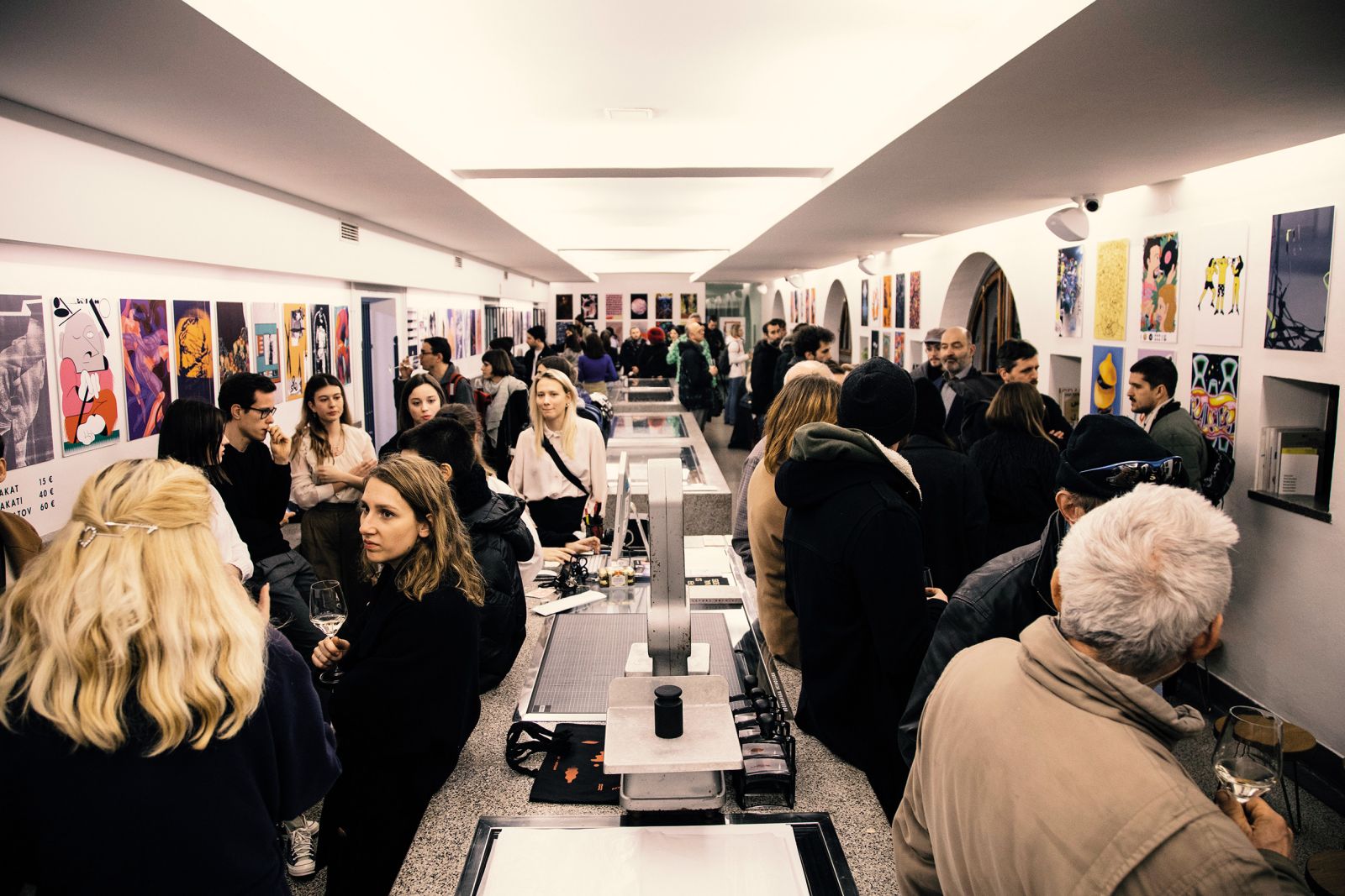 DobraVaga, ki deluje v nekdanji ribarnici na osrednji ljubljanski tržnici, je naša prva galerija, ki je pričela mlade umetnike in umetnice, ki so komaj končali izobraževanje, sistematično postavljati na umetniški zemljevid. Fotografija je bila posneta na eni prejšnjih edicij dogodka appointMENT, ki je razstava plakatov, ustvarjenih za nastopajoče na glasbenem festivalu MENT.