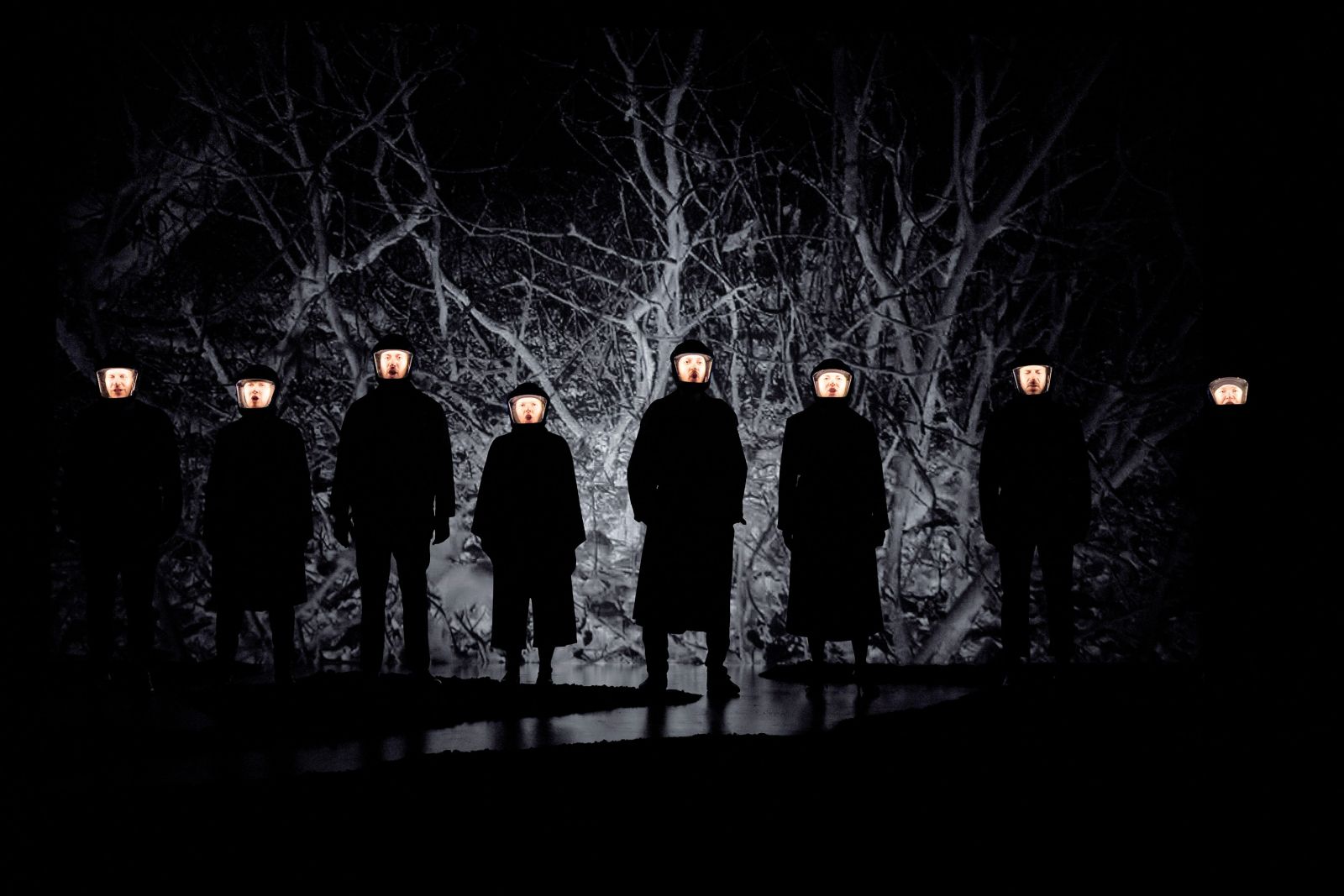 Igralci, odeti kot obcestne svetilke, velikokrat ponovijo verz »Bodi svetilka, če ti je težko biti človek«.