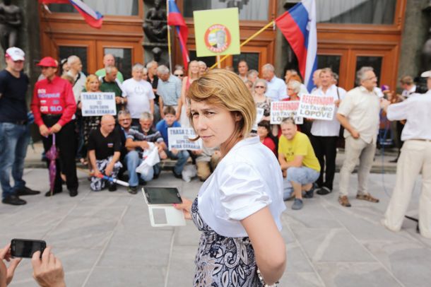 Poslanka SDS Alenka Jeraj pred parlamentom ... s telefonom v roki