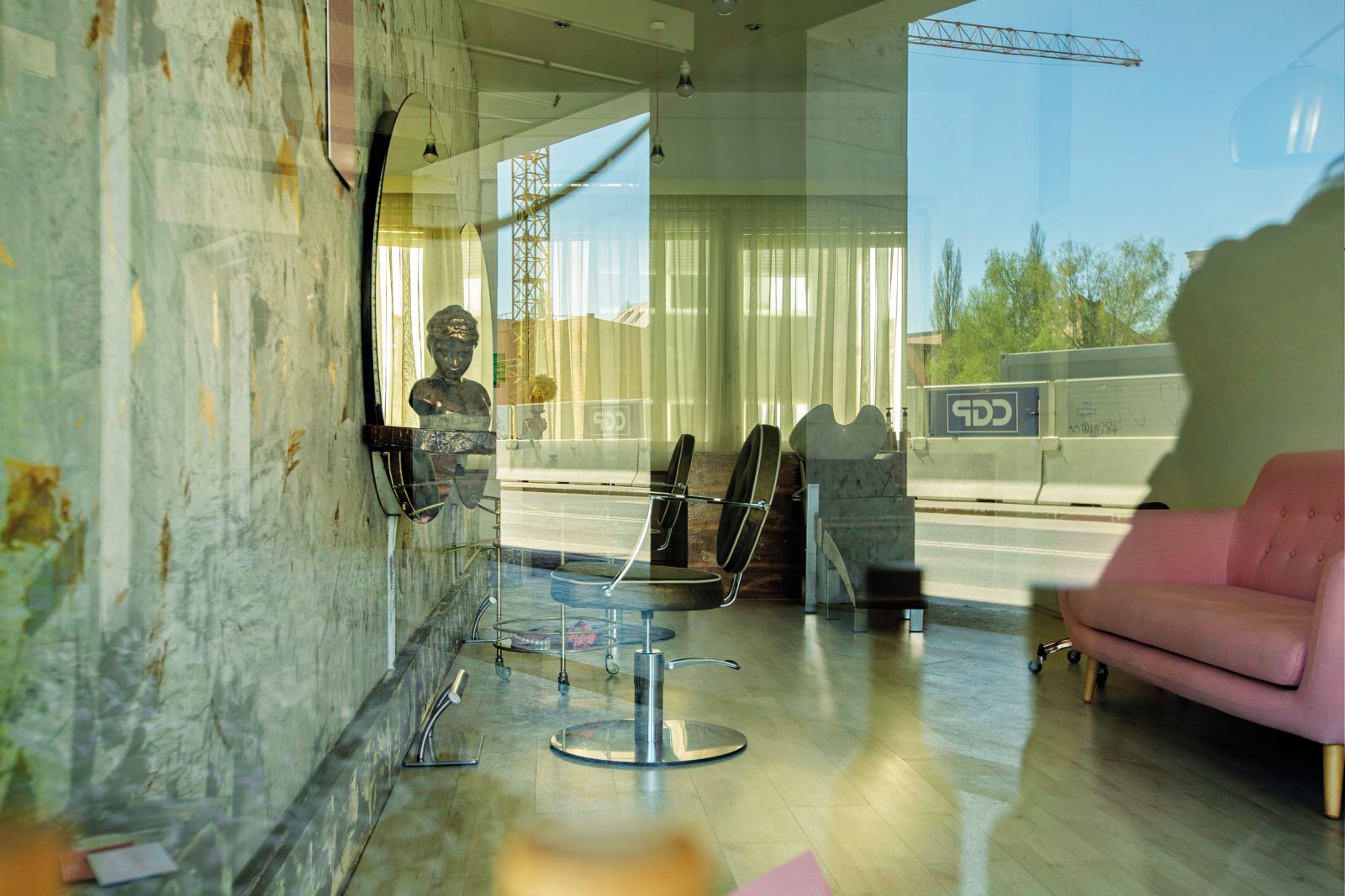 Fotografija z naslovom 09. 04. 2020, 13:07 razkriva zaprti salon ob Slovenski cesti, odsev z ulice pa tedaj opustelo gradbišče novega Šumija, ki je zdaj že skoraj zgrajen.
