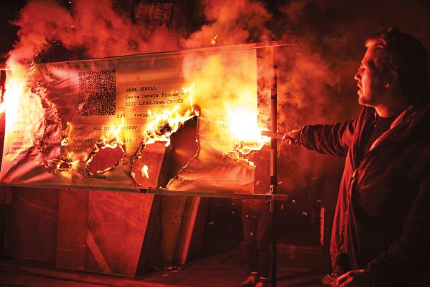 Protestni zažig položnice za plačilo policijske kazni za 34.340, 56 evrov zaradi sodelovanja pri branju ustave na Trgu republike leta 2020