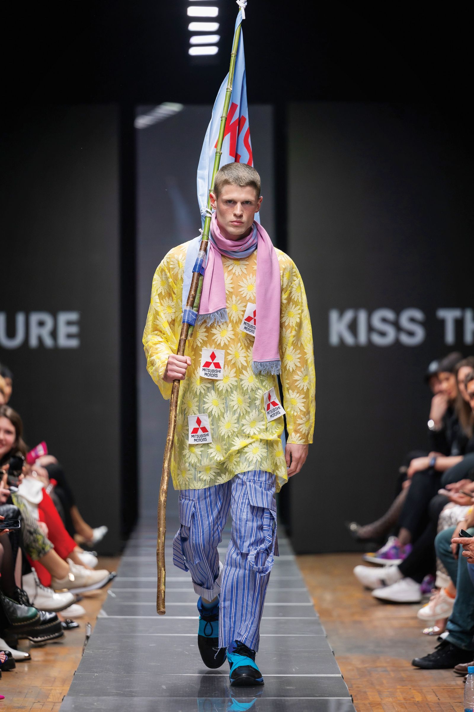 Predstavitev najnovejše kolekcije Kiss The Future na Ljubljana Fashion Weeku: ustvarjena je bila po vzoru steampunk estetike iz serije filmov Pobesneli Max. Med modnimi dodatki smo opazili lok, fračo, zastavo in celo embalažo pralnega praška, predelano v nahrbtnik.