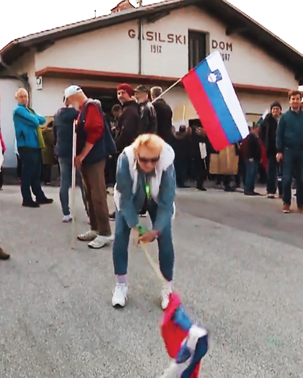 Izvorni prizor udarjanja z zastavo, ki se je zgodil na protimigrantskem protestu aprila 2019 v Jelšanah