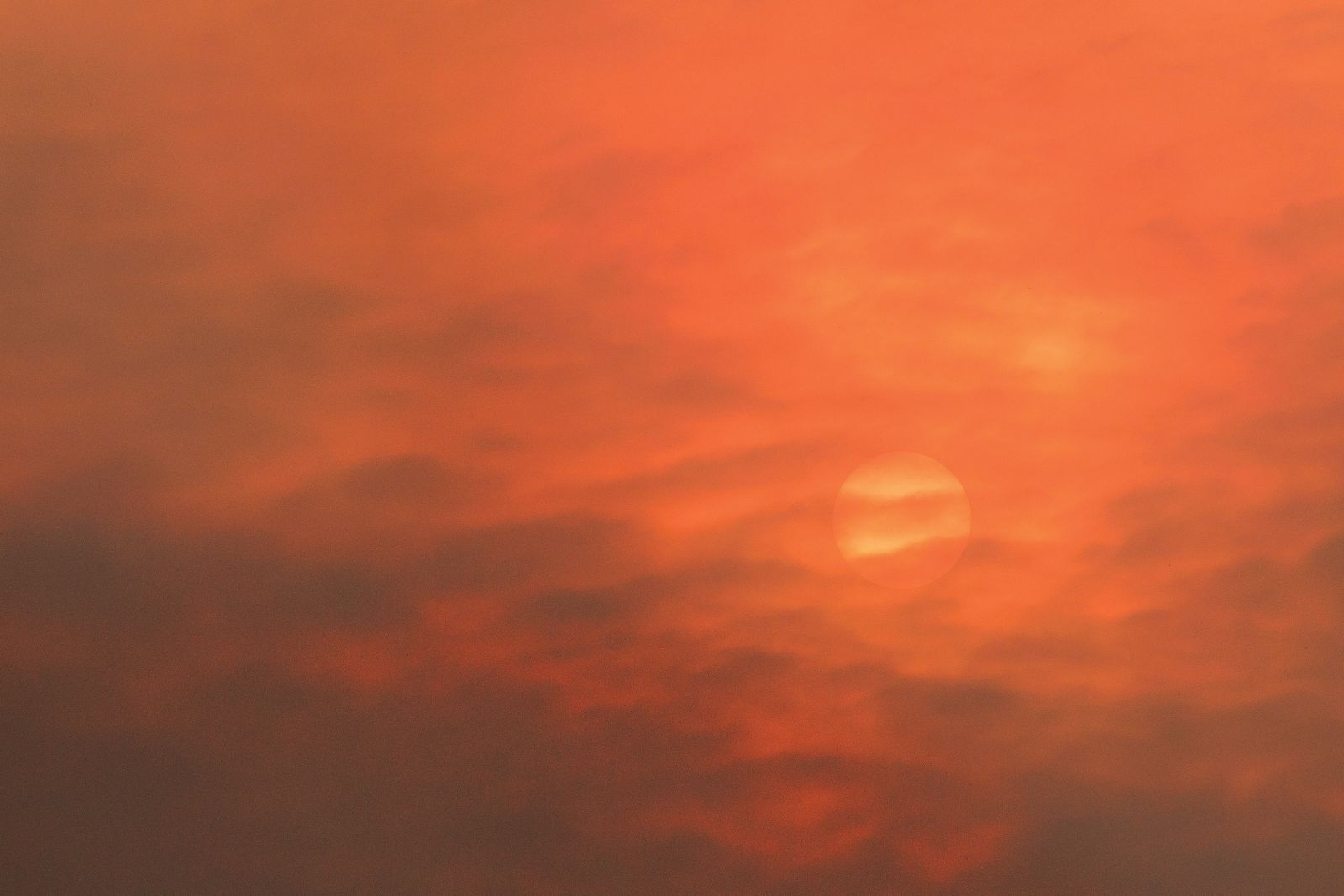 Gost dim zastira zahajajoče sonce nad Kostanjevico na Krasu, 20. 7. 2022