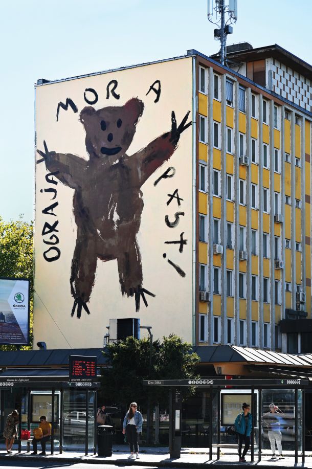 Na slepi fasadi nekdanje Občine Šiška nas prijazni medved opozarja, da je na slovenskohrvaški meji še vedno ograja.