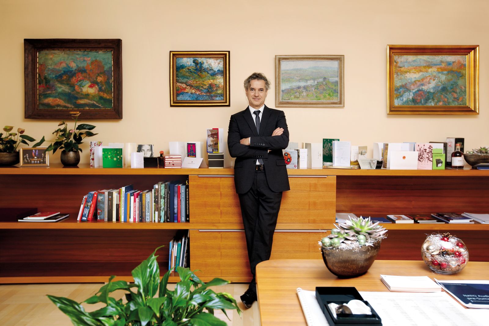 Umetniška dela slovenskih impresionistov v pisarni predsednika vlade. Na omari so novoletne voščilnice, čisto levo pa fotografije predaje poslov med Janezom Janšo in Robertom Golobom. Nastala je 1. junija 2022.