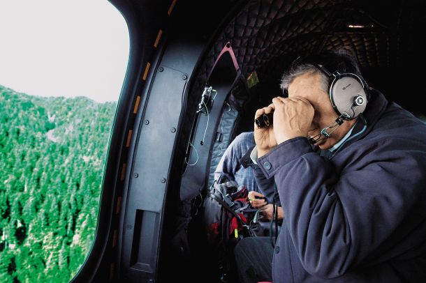 Nekdanji ljubljanski nadškof Alojz Uran si iz helikopterja ogleduje pokljuške gozdove 