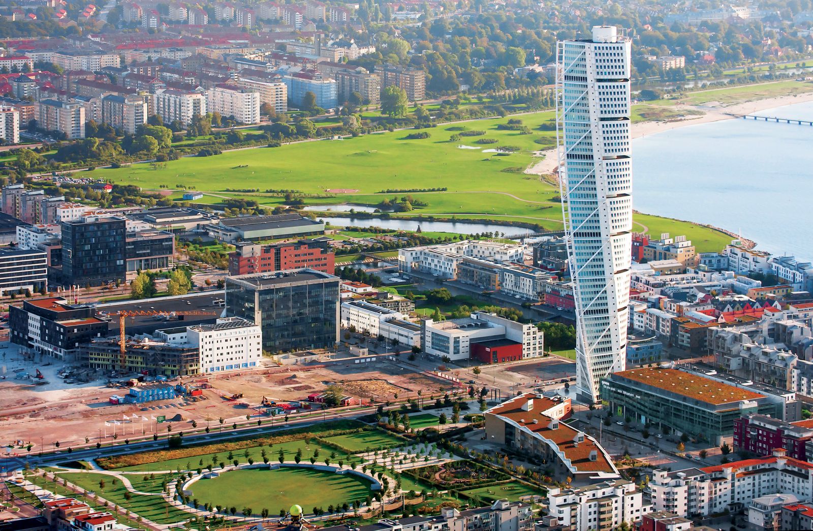 Pogled proti starejšemu delu Malmöja pokaže razliko med tem in novim razvojnim območjem Zahodnega pristanišča. V ospredju je osrednji park, ob njem osnovna šola in znamenita Calatravova stolpnica Turning Torso ter nekatera še nepozidana zemljišča.