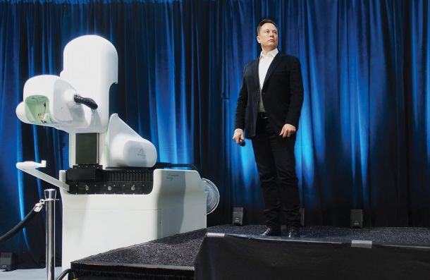 Elon Musk in prototip Neuralinkovega kirurškega robota, ki naj bi  opravljal celoten poseg, od reza prek odstranitve dela lobanje do vstavitve elektrod in namestitve možganskega vsadka.