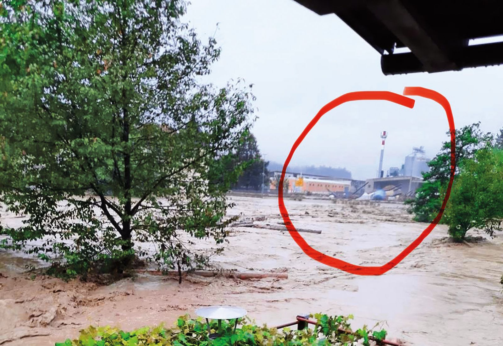 ... na drugi fotografiji kupa hlodovine ni več, posamezni hlodi pa plavajo po reki. Vse kaže, da je reka nepravilno skladiščen les odnesla in zajezila most, zaradi česar se je voda še dodatno dvignila.