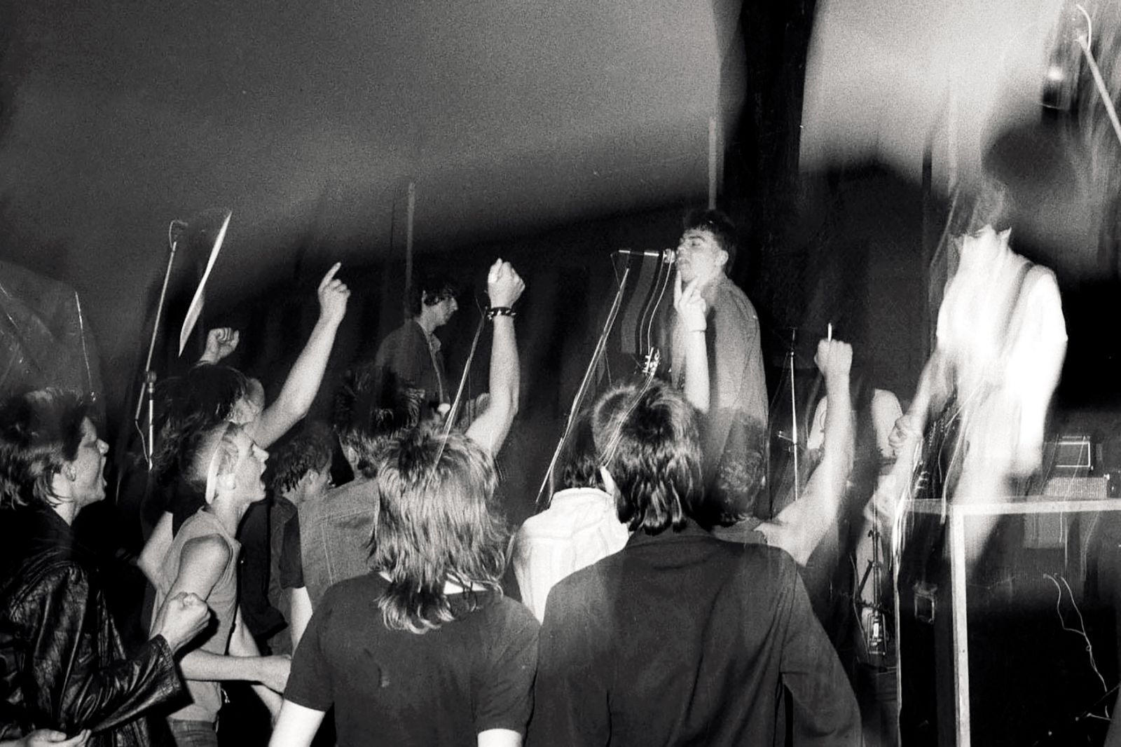 Dinamika občinstva in nastopajočih na koncertu benda O! Kult na novomeški gimnaziji leta 1983.
