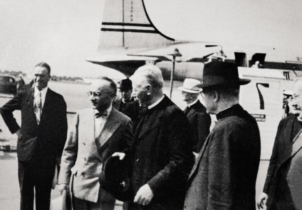 Gregorij Rožman je 2. julija 1948 prišel v ZDA. Na letališču ga je med drugim pozdravil Miha Krek (ob škofu z metuljčkom), podpredsednik jugoslovanske kraljeve vlade v izgnanstvu. Krek je bil sicer obsojen na istem procesu kot Gregorij Rožman, ob koncu vojne pa je živel v Rimu.
