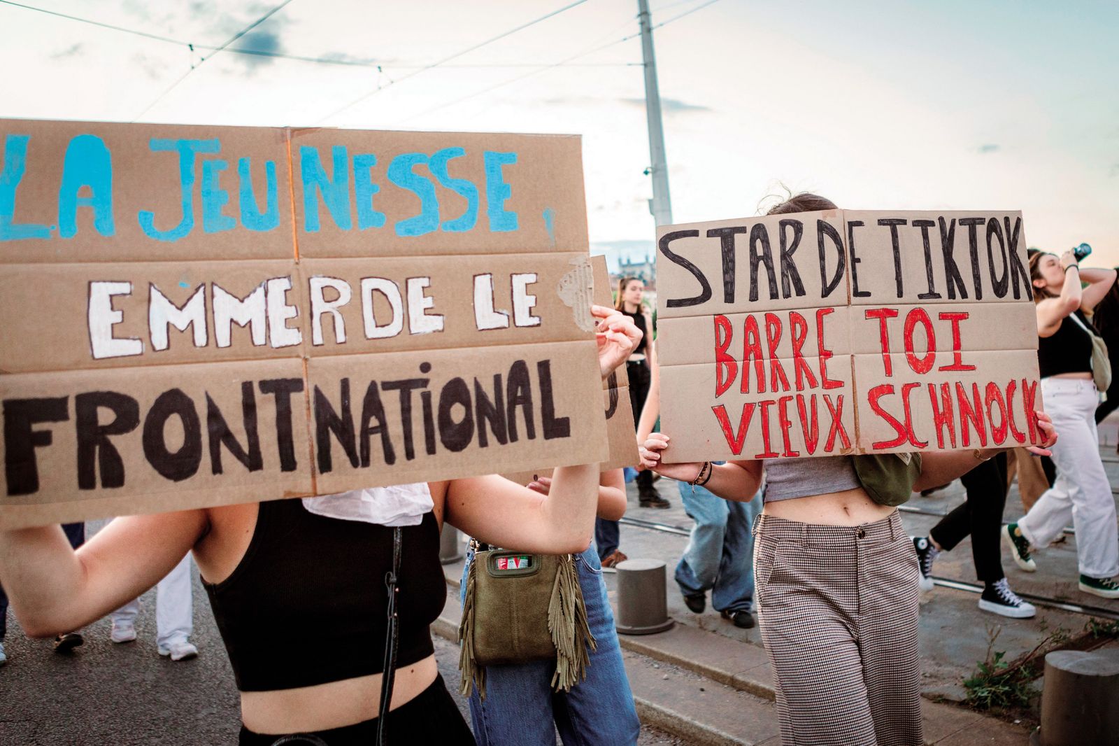 Protest proti Nacionalnemu zboru in Jordanu Bardelli v Lyonu v Franciji. Napis desno: »Zvezda TikToka, poberi se, stari prdec.«